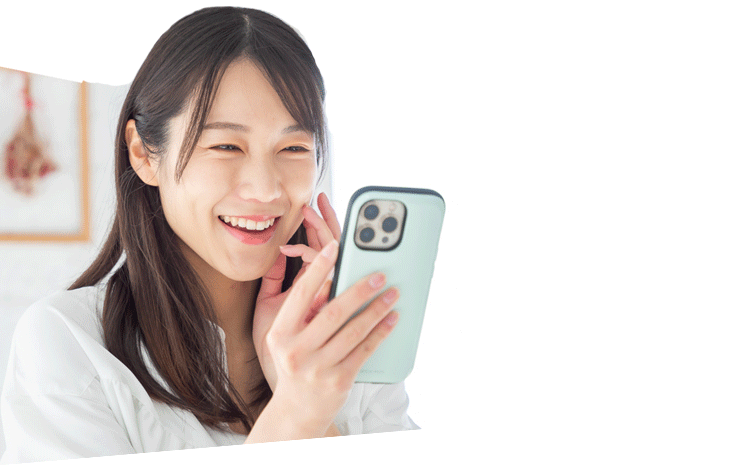 笑顔でスマートフォンを眺める若い女性